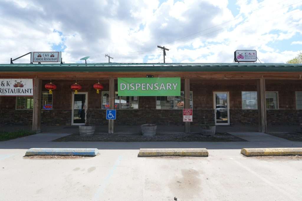 Exterior of Plains dispensary, MT, with cannabis signage and parking area.