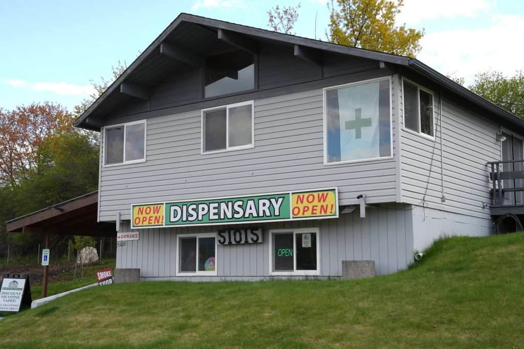 Exterior of dispensary in Polson, MT, with visible cannabis signage and parking area.